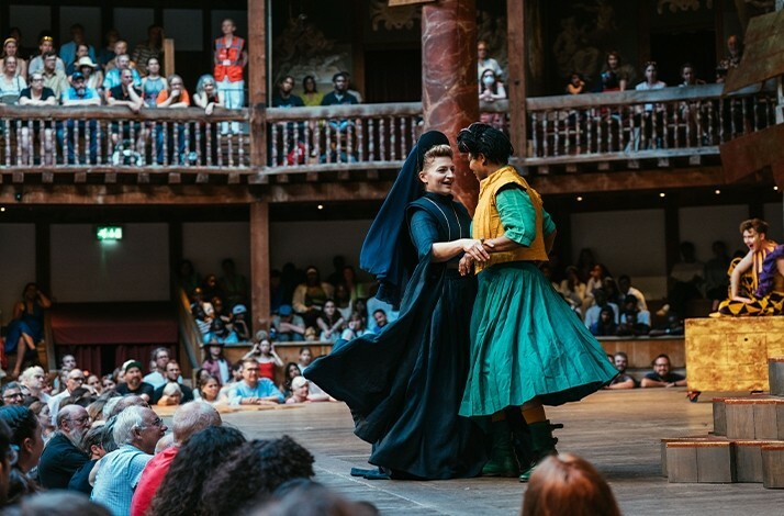 Two costumed actors of The Twelfth Night perform on stage at the Globe Theatre.