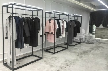 Clothing racks filled with various garments inside the Ocelote fashion house.