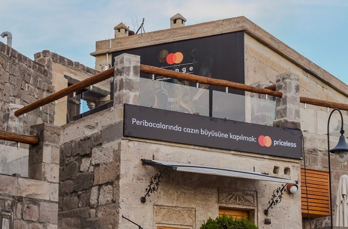 Exterior view of Taşkonaklar Hotel in Cappadocia featuring a terrace with Priceless branding.