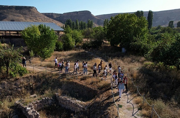 A group of visitors exploring the Şahinefendi Excavation Site in Cappadocia.