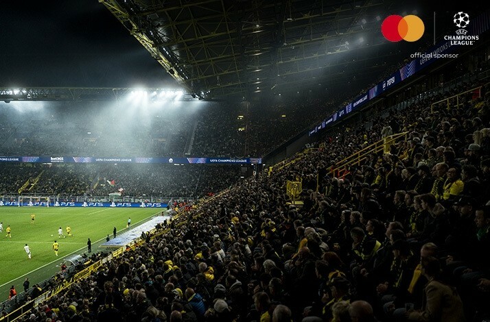 Bleachers full of football fans waving flags at an UEFA Champions League match