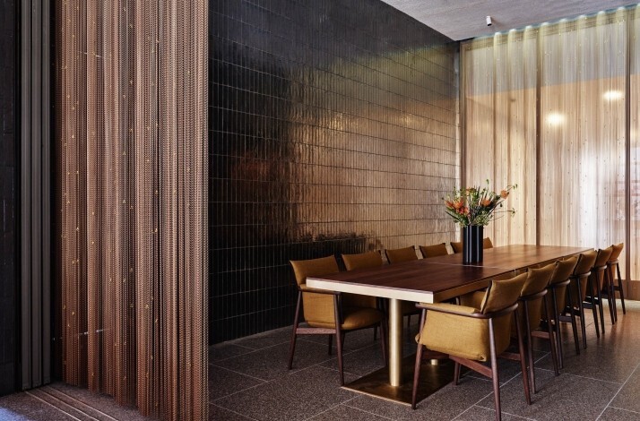 Elegant private dining room with a long table, upholstered chairs, and soft light filtering through sheer curtains. At the New York Philharmonic.