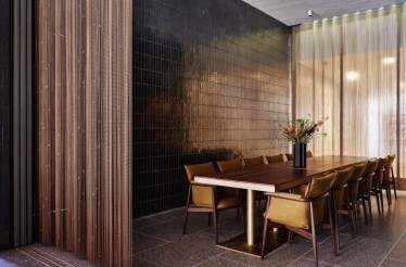 Elegant private dining room with a long table, upholstered chairs, and soft light filtering through sheer curtains. At the New York Philharmonic.