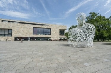 A striking sculpture of a man is displayed in front of Goethe House