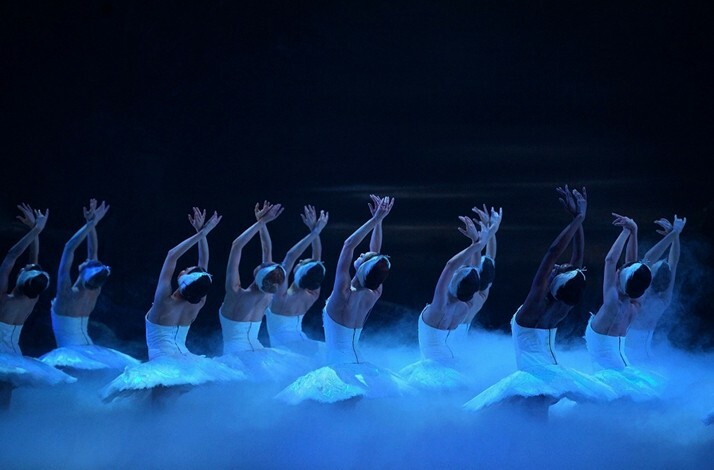Graceful ballerinas perform Swan Lake amidst ethereal mist and dramatic lighting