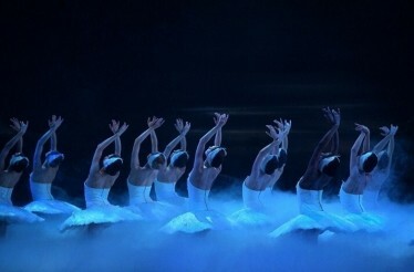 Graceful ballerinas perform Swan Lake amidst ethereal mist and dramatic lighting