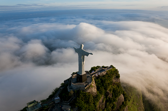 Bird view on the Christ the Redeemer, statue of Jesus overlooking clouds.