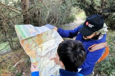 Two men look at a map during a hiking adventure in the Hymettus mountain range with expert guides from Trekking Hellas Athens.