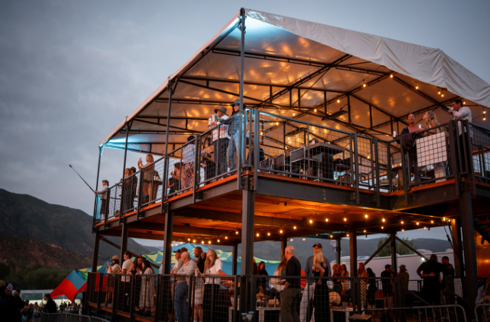 Several spectators on the private Mastercard Cabin with elevated views of the stage at Up in the Sky Festival.