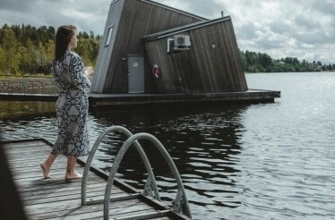 A person enjoying the view from the deck of Artic Bath's floating cabin