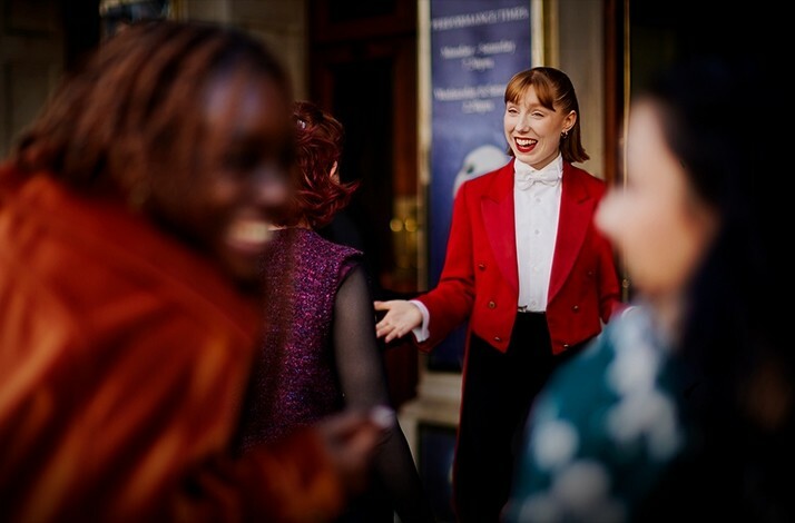 Red Coat concierge greeting the guests at London's Cambridge Theatre.