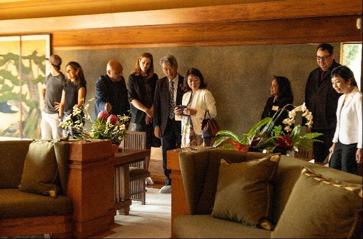Group of visitors touring around Frank Lloyd Wright's iconic Hollyhock House with the house's curator and director.