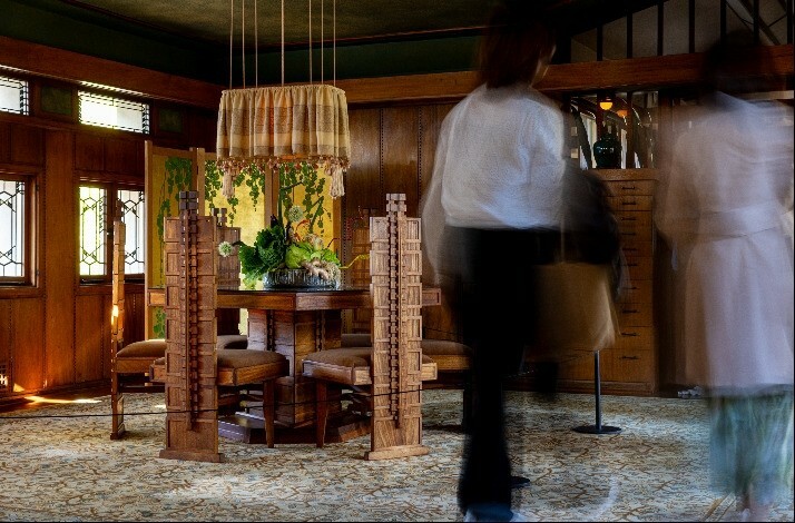 Group of visitors touring around the interior of Frank Lloyd Wright's iconic Hollyhock House.