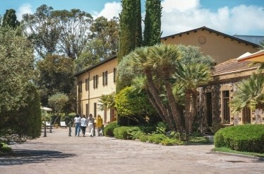 People walk near the Sella & Mosca winery building.