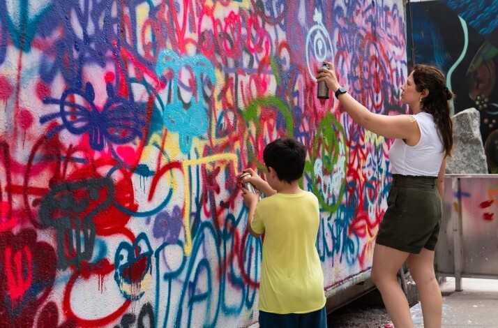Two people spraying on the street art museum Wynwood Walls.