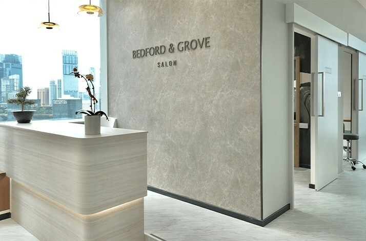 Modern office interior of Bedford & Grove Salon featuring a reception desk and a large window