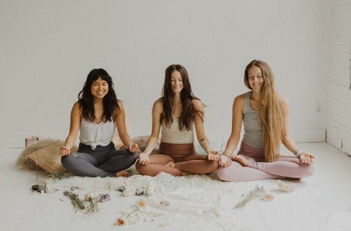 Three people smiling doing yoga