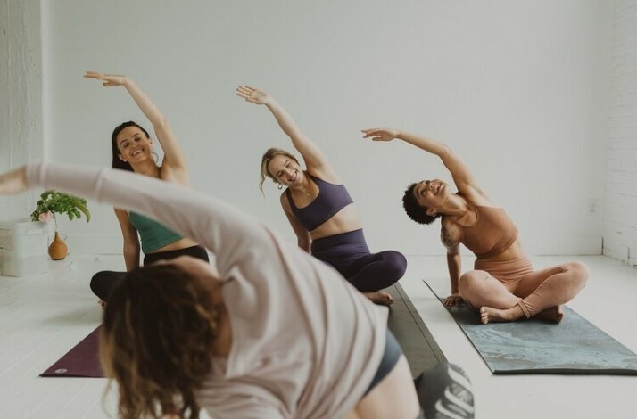 A group of people smiling doing yoga