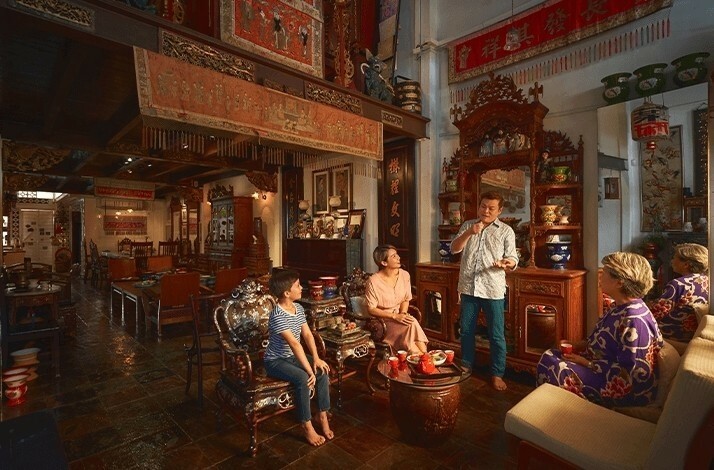 People listening about Peranakan heritage that blends Chinese and Malay influences in private museum inside Alvin's home.