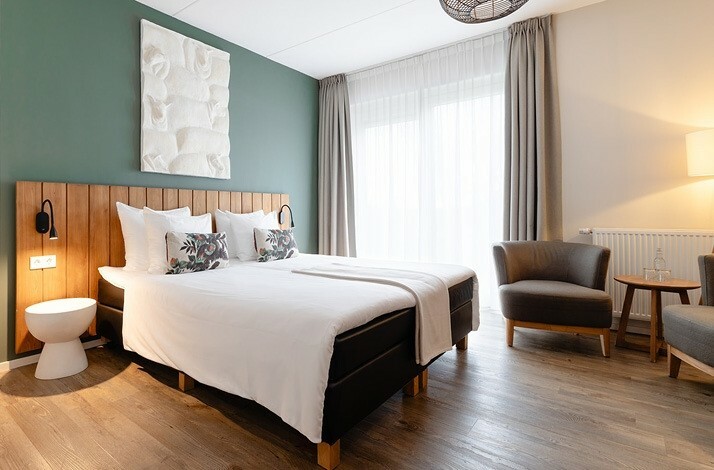 Modern bedroom with a minimalistic design, warm wood accents, and natural light.