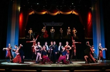 A vibrant tango performance with dancers and musicians on a grand stage