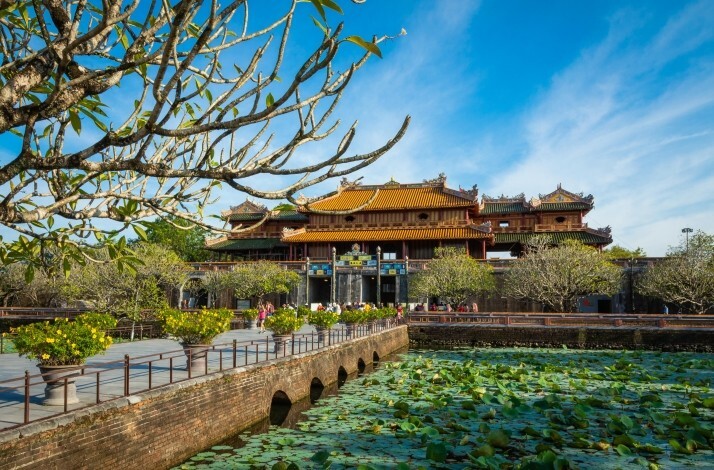 A wide shot of the Imperial Citadel of Hue Vietnam, showcasing a serene courtyard and the grand palace from the distance.