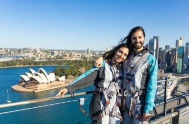 A couple wearing BridgeClimb suits atop the Sydney Harbour Bridge.