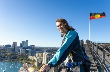 A man wearing BridgeClimb suits atop the Sydney Harbour Bridge.