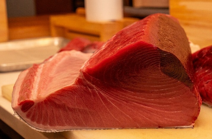 A close-up shot of vibrant red fish meat placed on a table.