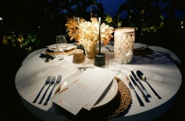 A beautiful, dimly-lit table ready to serve at home, arranged by a The Sage Experience butler. 