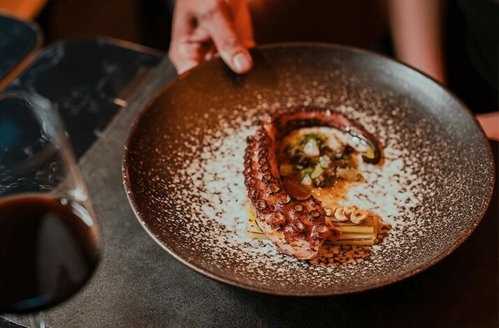 Octopus dish served at VUE restaurant with a glass of red wine.