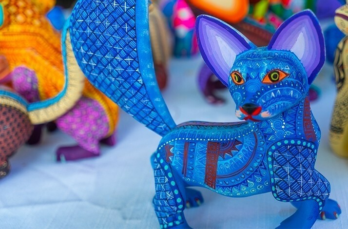 A bright blue, hand-painted figurine of a fox-like creature is on display.