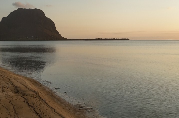 A serene morning on a beach overlooking Le Morne Brabant mountain, Mauritius.