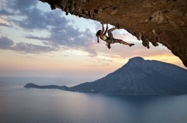 Climber on a cliff in Kalymnos Greece over the Aegean Sea