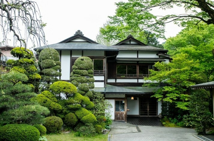 Traditional Japanese building surrounded by manicured greenery.