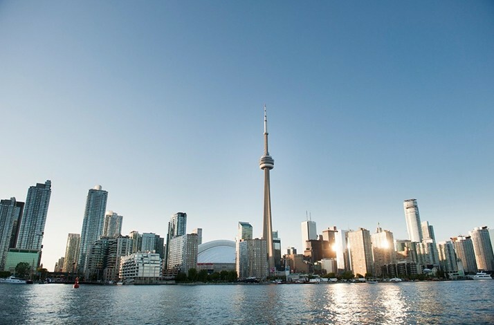 Toronto skyline from across the water, showcasing the city's modern architecture under a clear, bright sky
