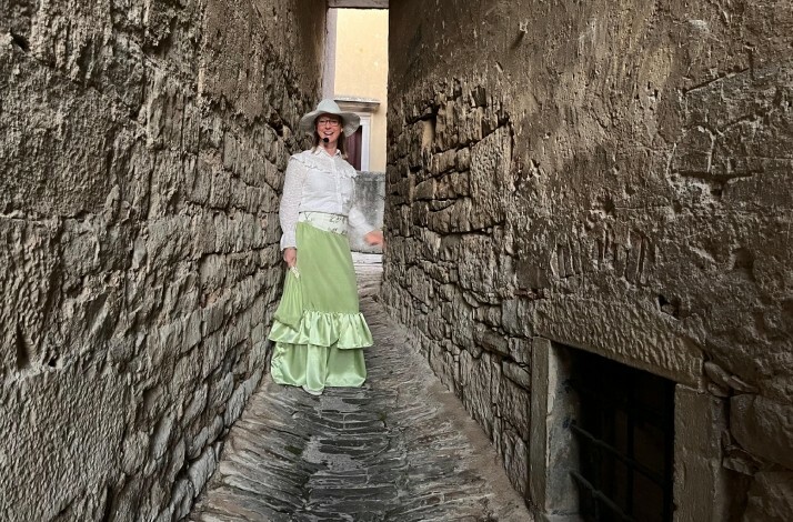 Costumed guide in a narrow stone alley in Buzet, Istria.