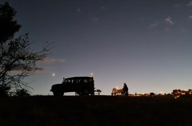 A person sitting at a table for custom night dining experience surrounded by distinctive fairy chimneys in a secluded valley in Cappadocia.