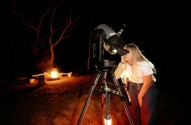 A woman stargazing with telescopes in the Blue Mountains, UNESCO World Heritage Site.