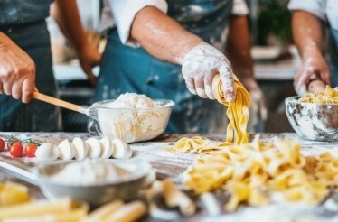A group of individuals making pasta from scratch