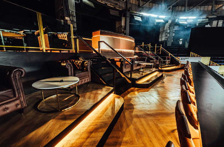The interior of the VIP lounge on the Rajadamnern Stadium with armchairs and a bar.