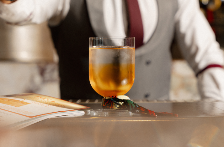 A bartender preparing a drink with ice cubes.