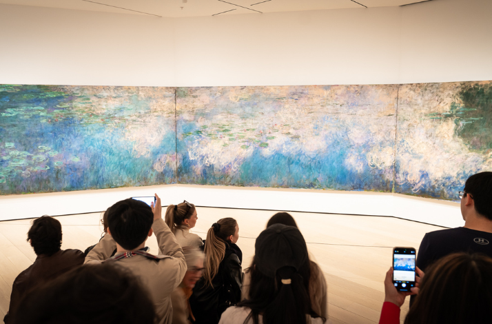 Visitors viewing large abstract painting in the Museum of Modern Art in New York.