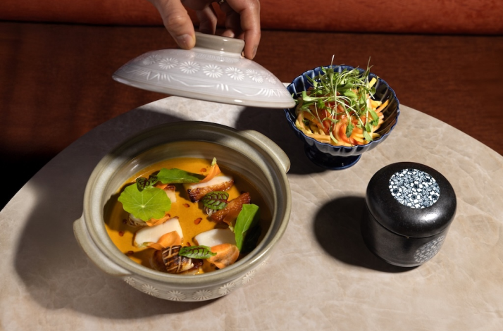 Chef-crafted course revealed in immersive art dining setting.
