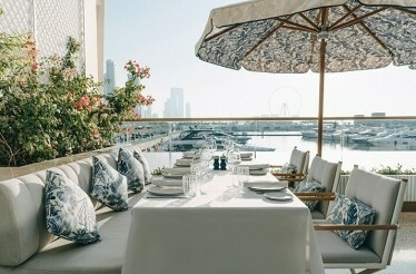 Outdoor table overlooking Dubai Harbour during the exclusive tasting menu experience.