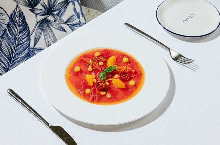 Vibrant seafood dish with citrus and garnishes on a white plate.