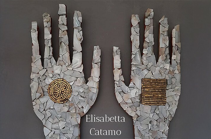 A wall decorated with pieces of stones shaping two human hands at private atelier of artist Elisabetta Catamo.