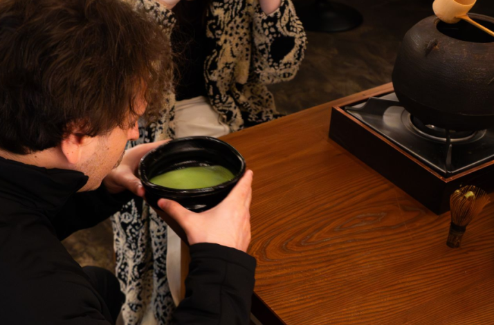 A person holding a large matcha cup served at THE GALLERY by odo.