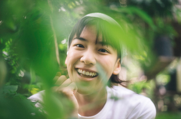 A person surrounded by lush green plants during a Thai herbal exploration.