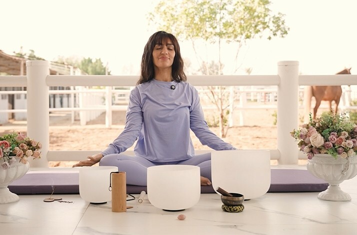 A smiling woman meditating on the terrace